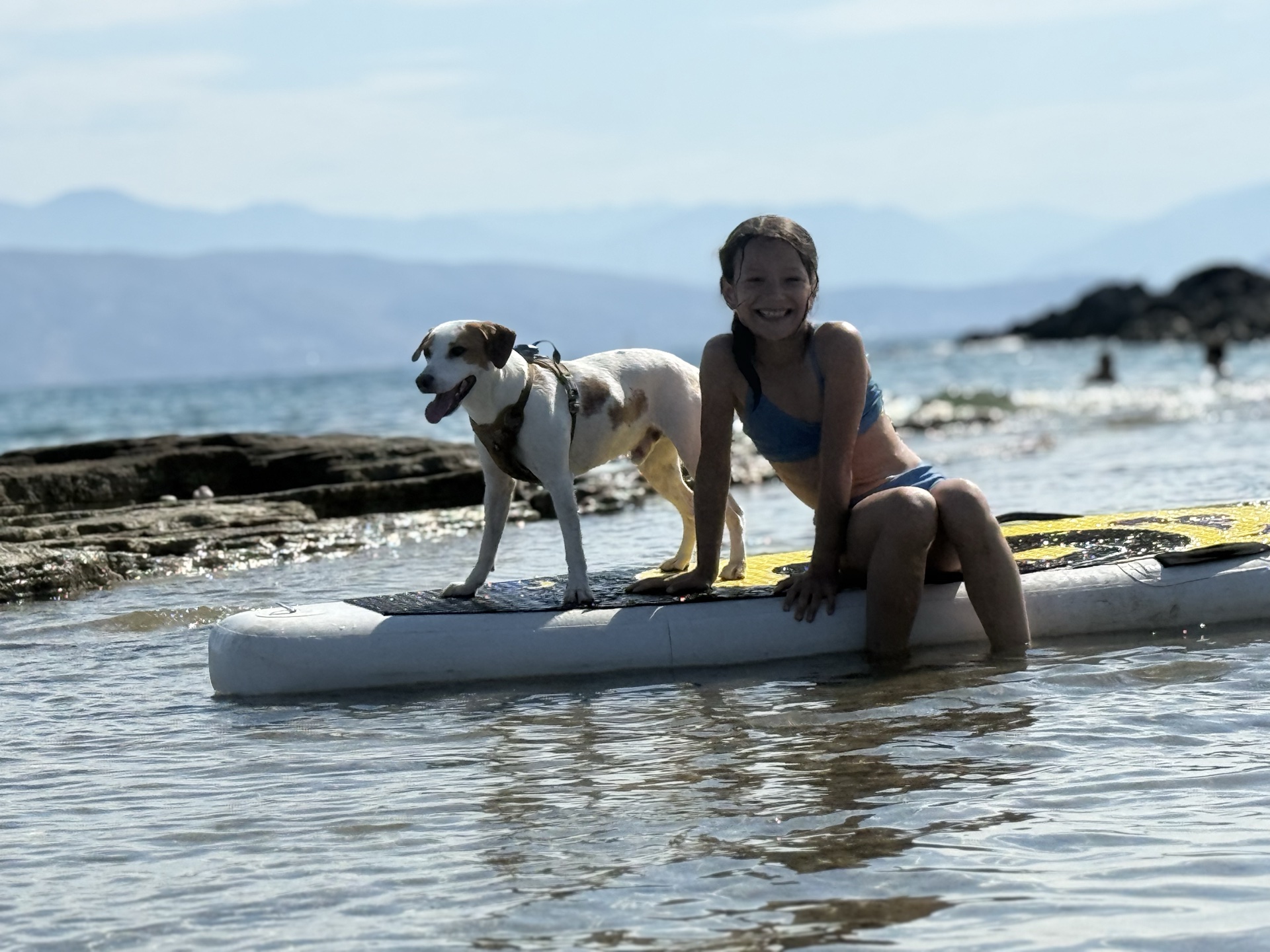 Rheo na paddleboardu se členem rodiny na Korfu.